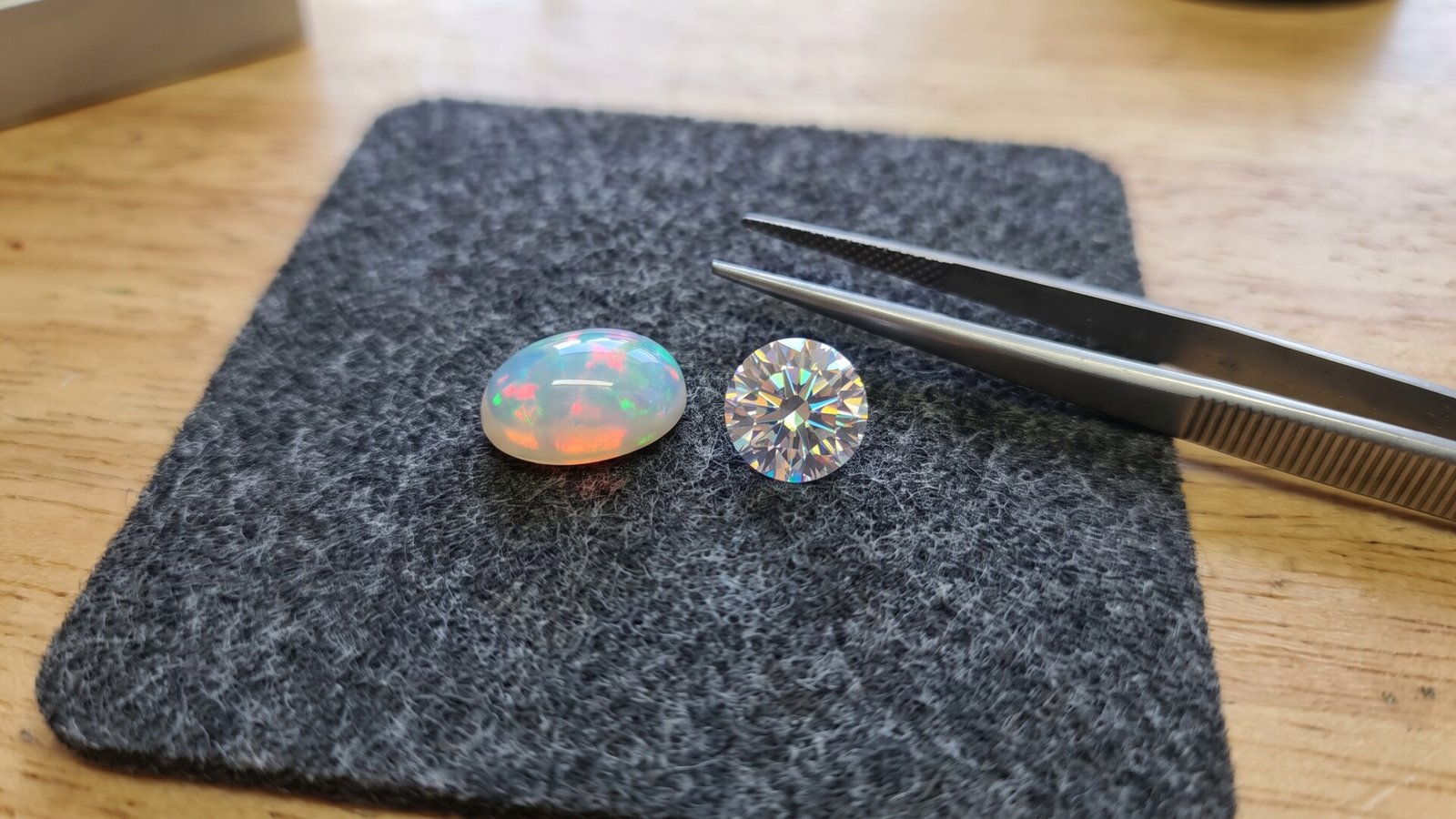 Oval cabochon opal and brilliant-cut moissanite comparing iridescent play-of-color with faceted fiery dispersion